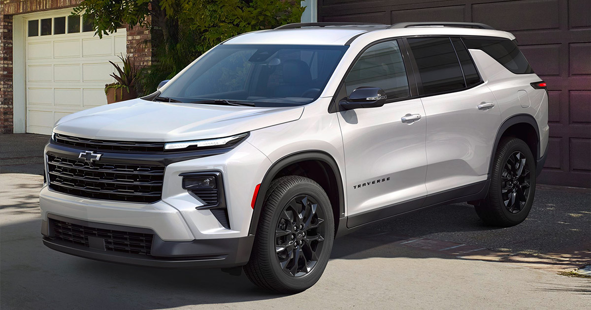 2024 Chevrolet Traverse white SUV parked in driveway, black wheels, modern design - Beck Motors Sunnyside