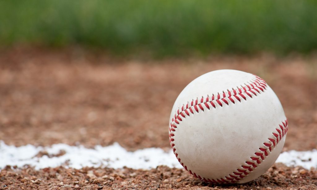 Image of a baseball on the ground of a baseball field