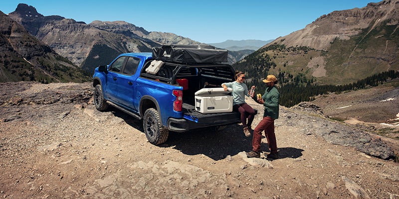Couple getting drinks from the bed of a 2025 Chevrolet Silverado 1500