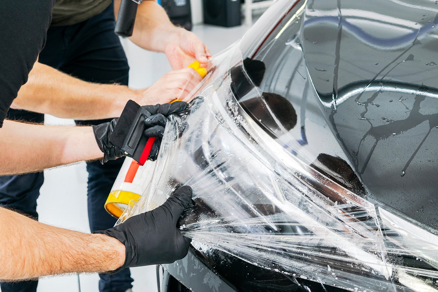 Applying protective film on car headlight
