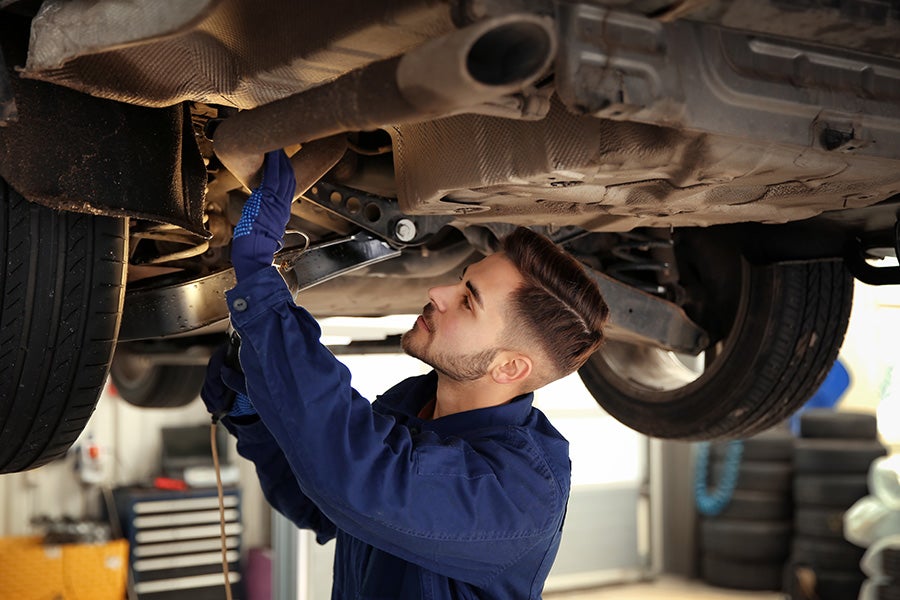 service manager checking underneath a vehicle img